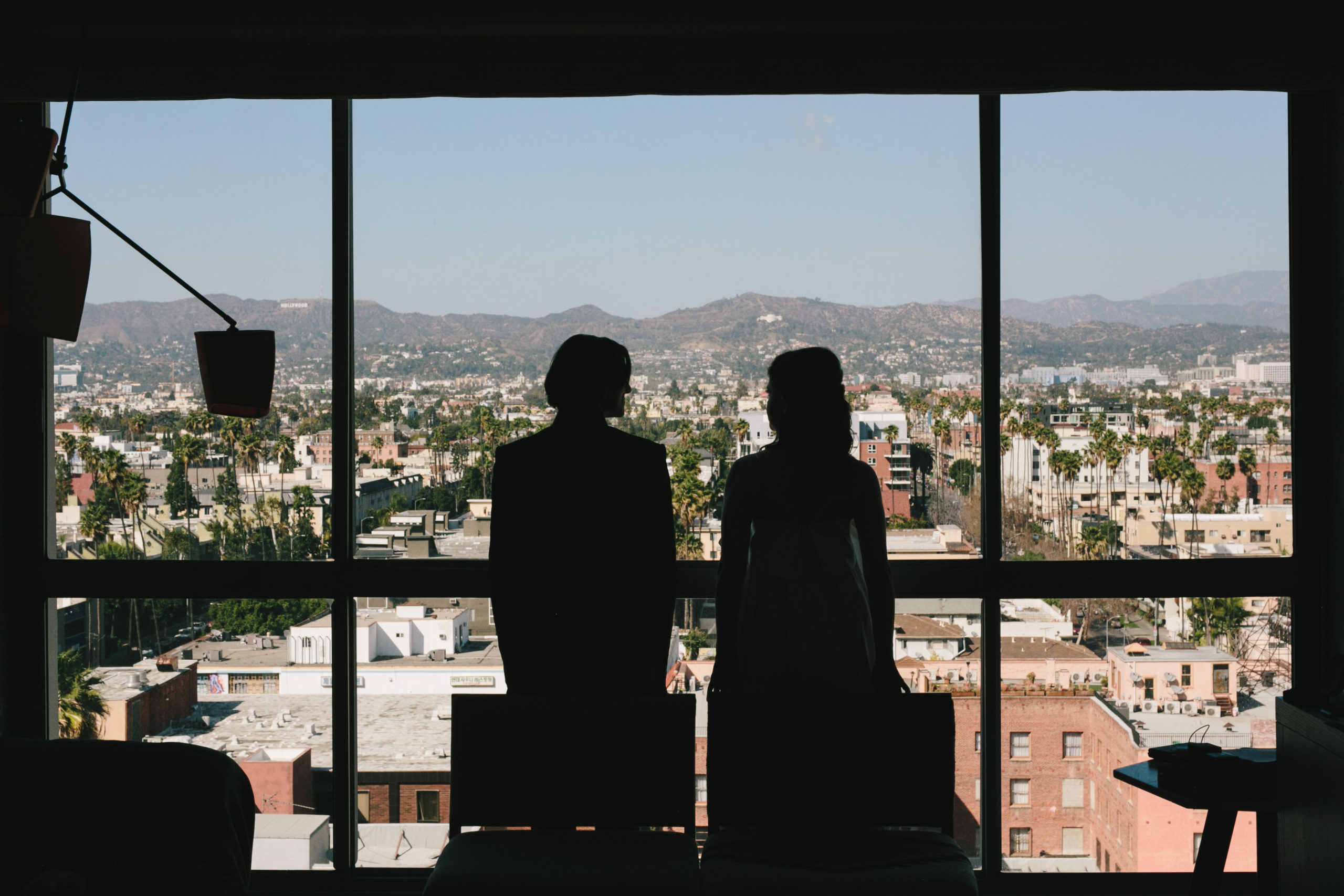 Bride and Groom look out from hotel over Los Angeles