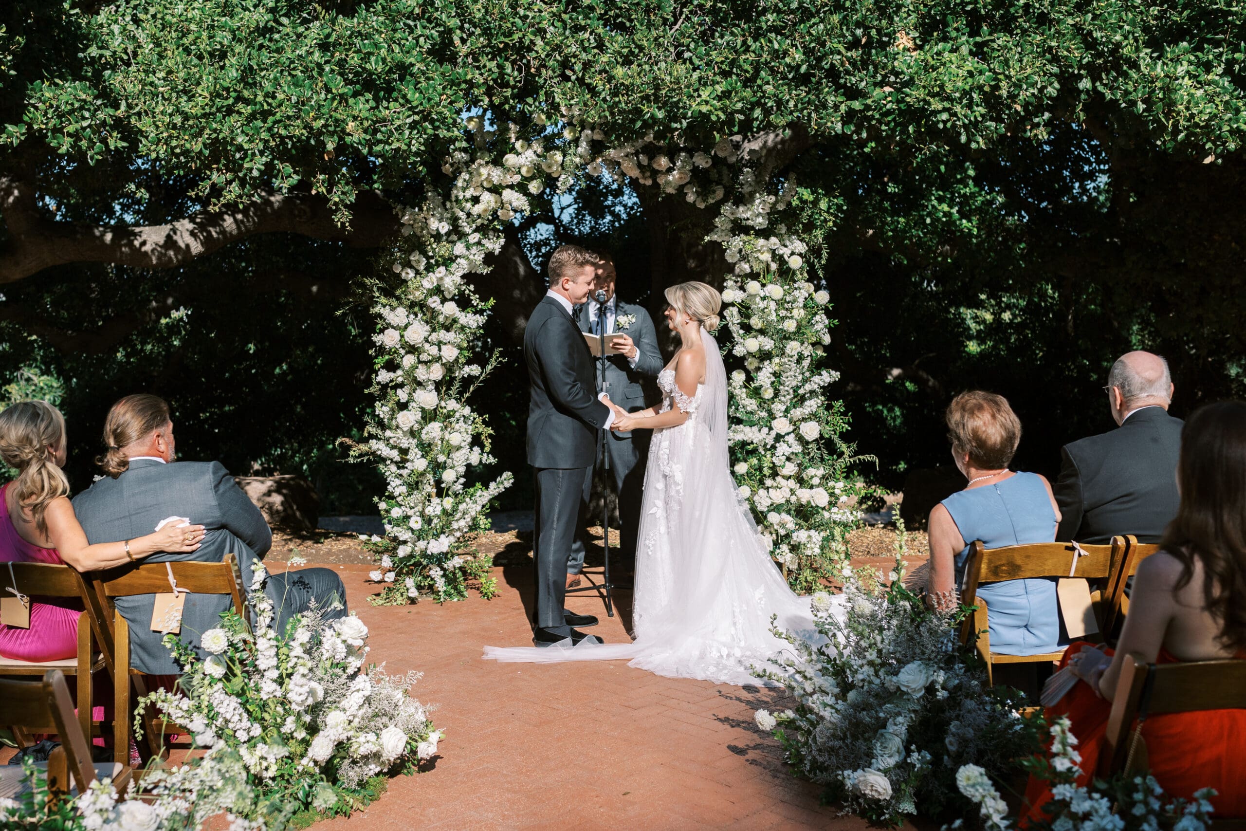 Quail Ranch wedding ceremony with white and green floral arch